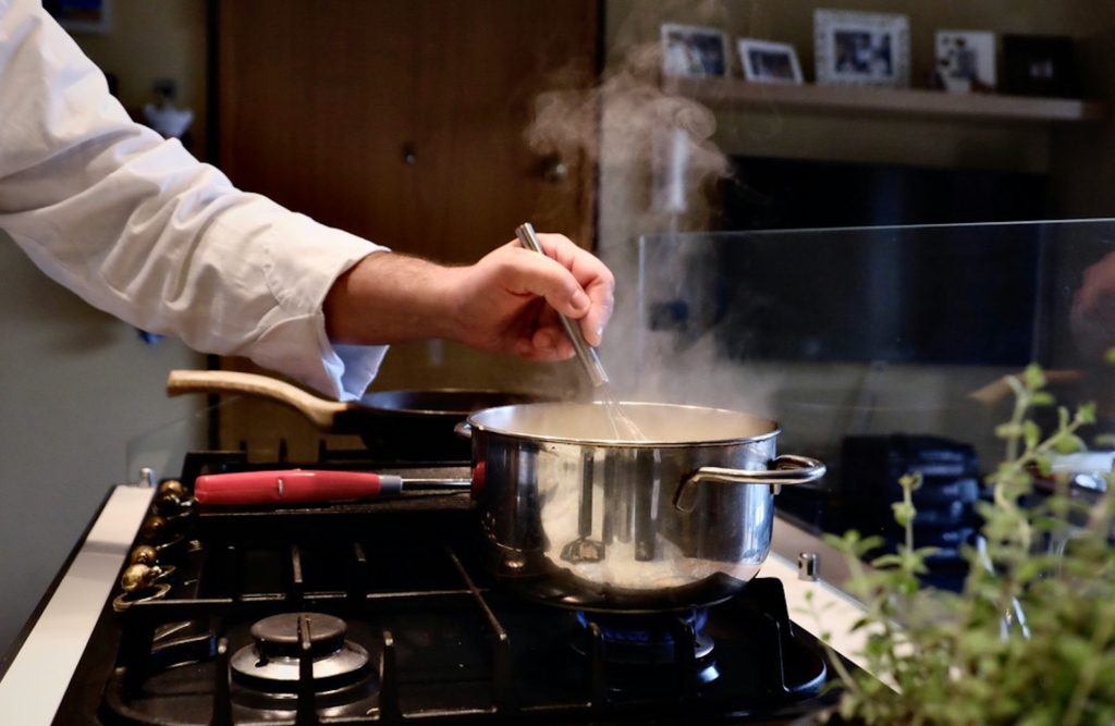person cooking in stainless steel cooking pot